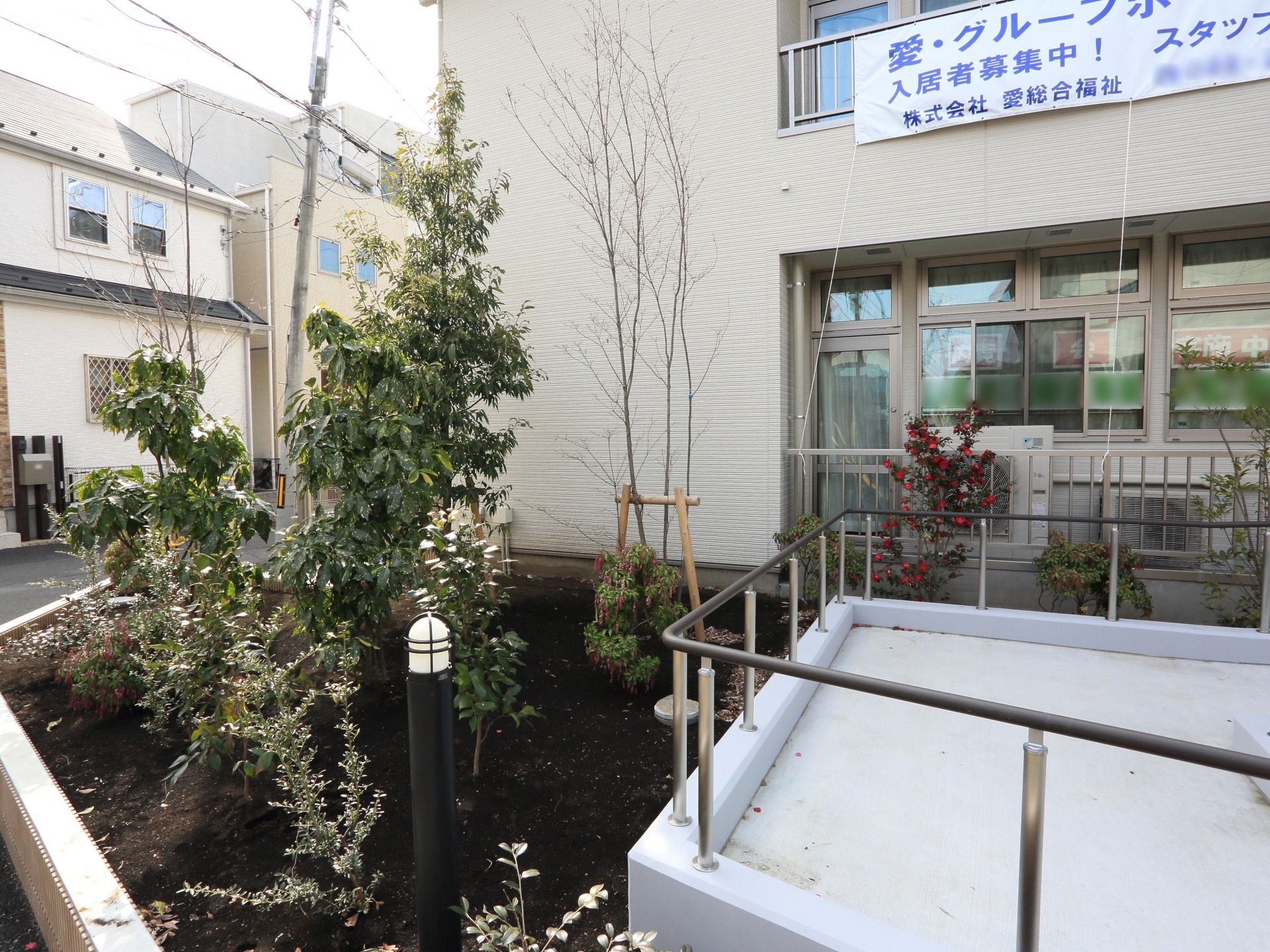 入口の向かって左側には、植え込みがあり、花が咲く木などが育てられている。夜間には、ライトがつく場所でもある。