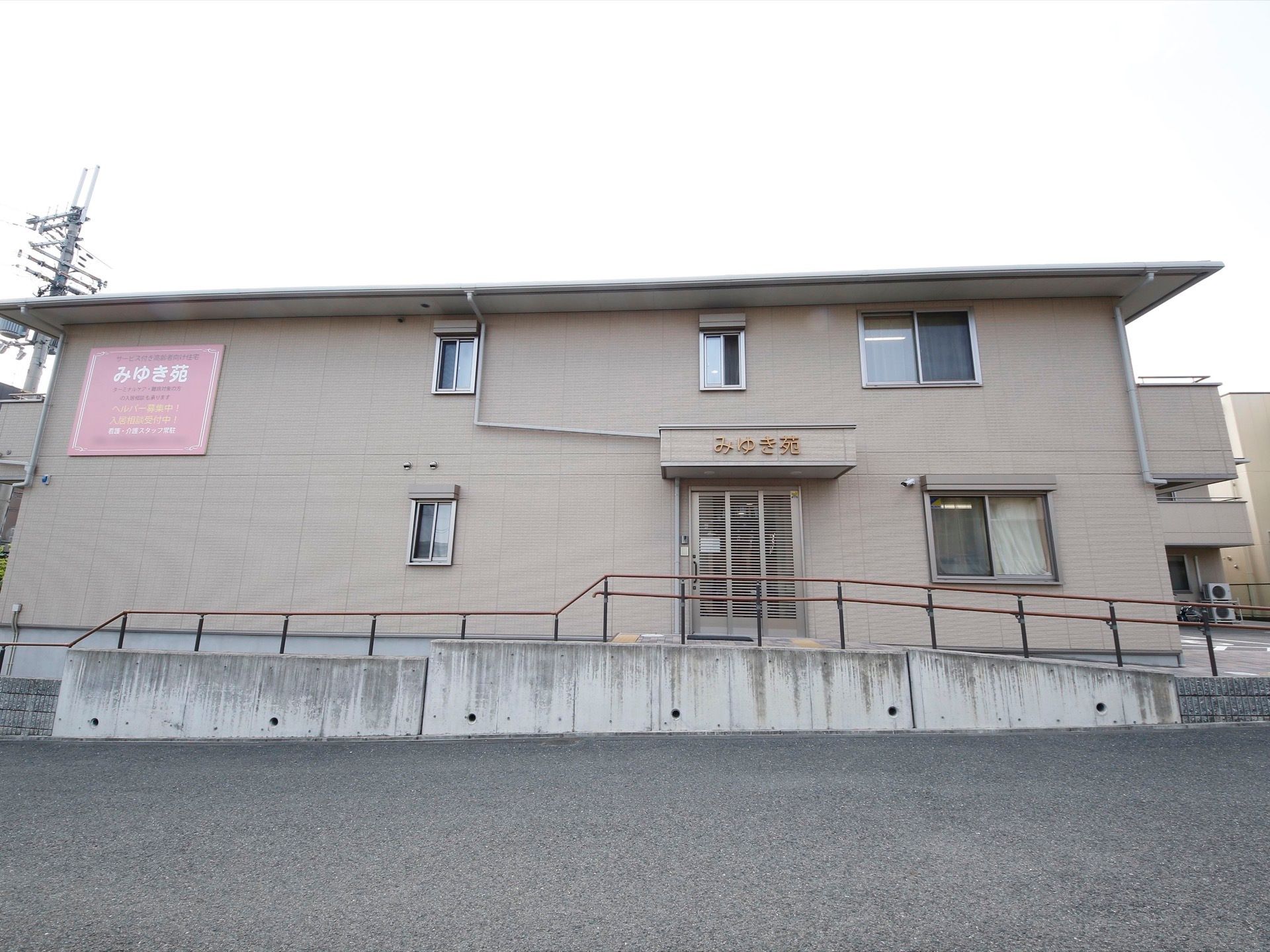 ２階建ての建物は落ち着いた雰囲気になっている。玄関前のスペースには屋根があり、スライド式の扉で安全に開閉できる。