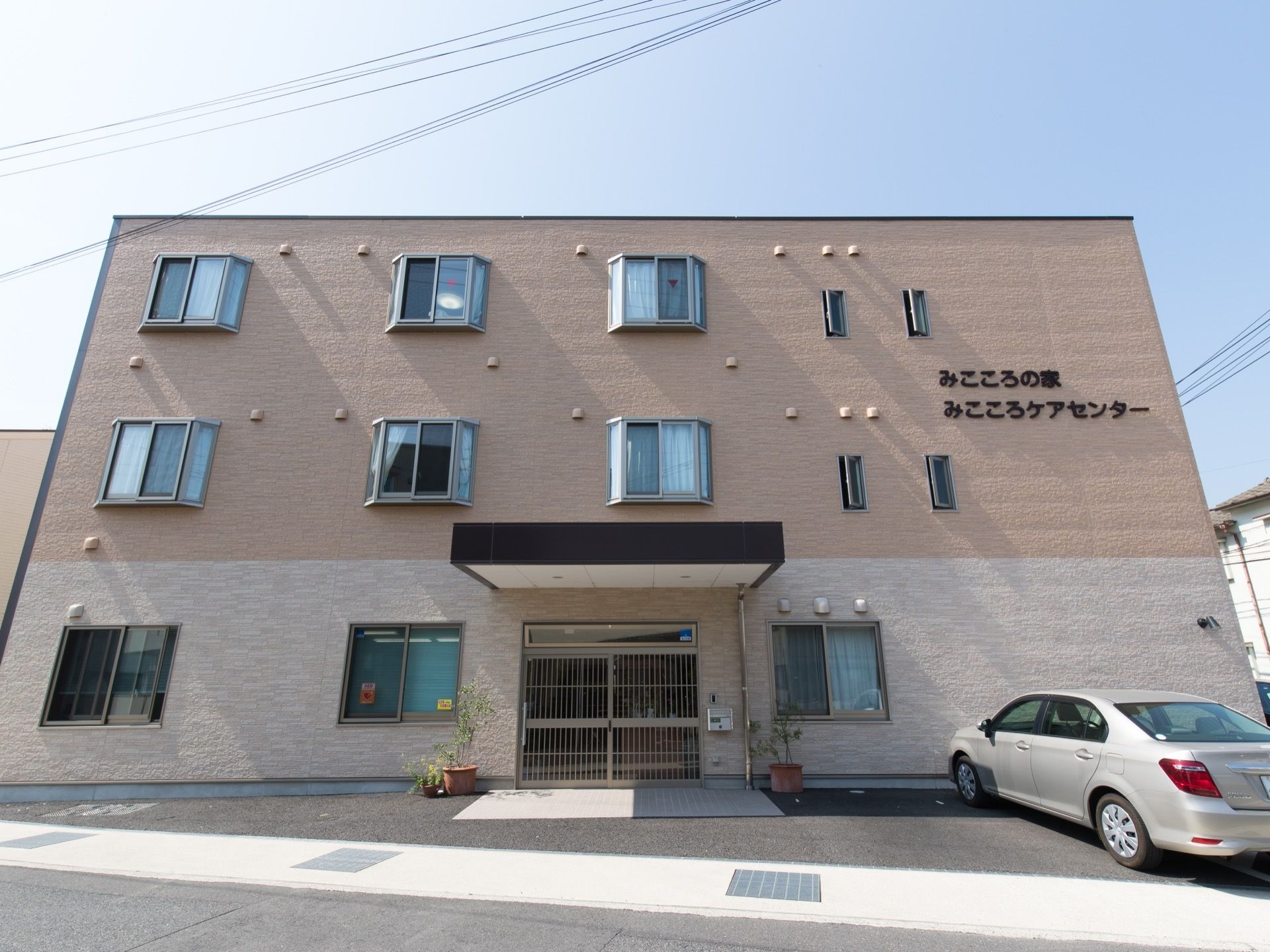 鉄骨造り3階建ての施設である。建物前と右横に駐車スペースが設けられている。２階と３階には、出窓が設置されている。