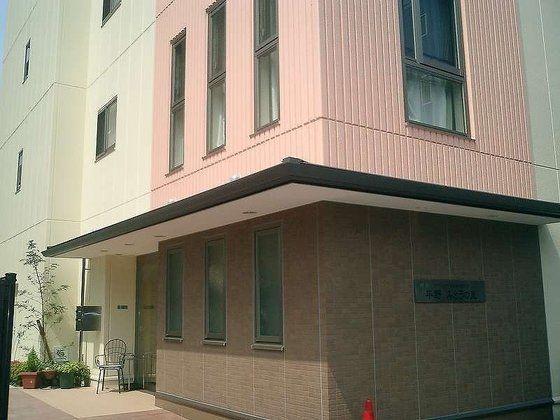椅子がひとつ置いてあり、プランターが並んでいるエントランス