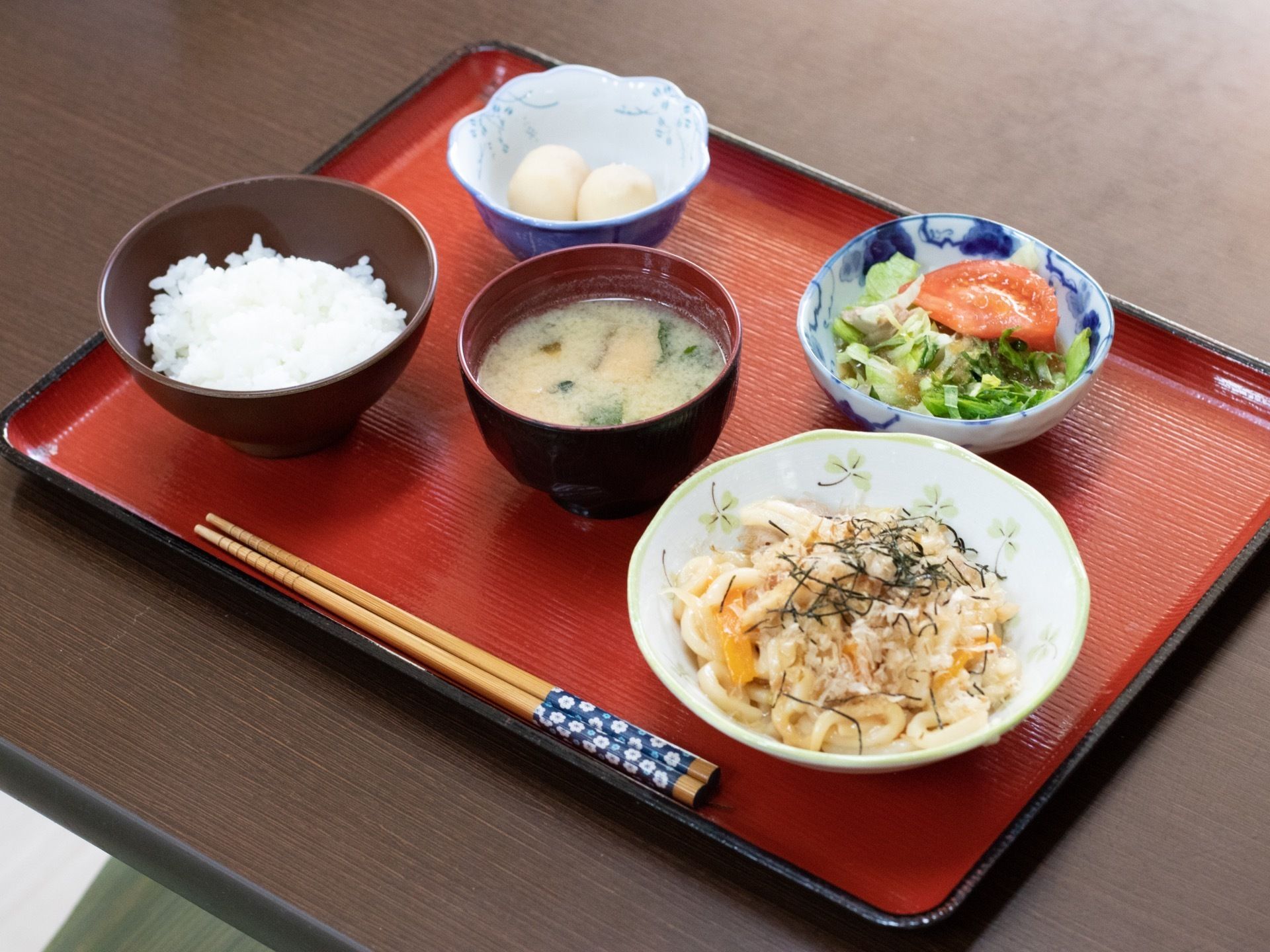 食事の一例の写真。テーブルに置かれたお盆の上にご飯やお味噌汁、おかずがのっておりバランスの良い食事となっている。
