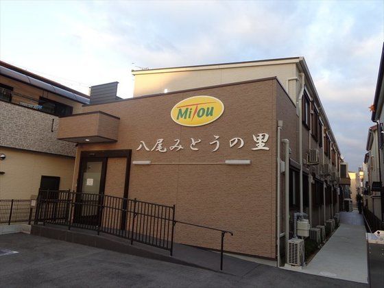 エントランス前にはスロープがあり、外壁に大きく施設名が書かれている建物
