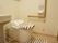 温水洗浄暖房便座付きの洋式トイレが設置されている。壁にはL字の手すり、操作パネル、ナースコールが取り付けられている。