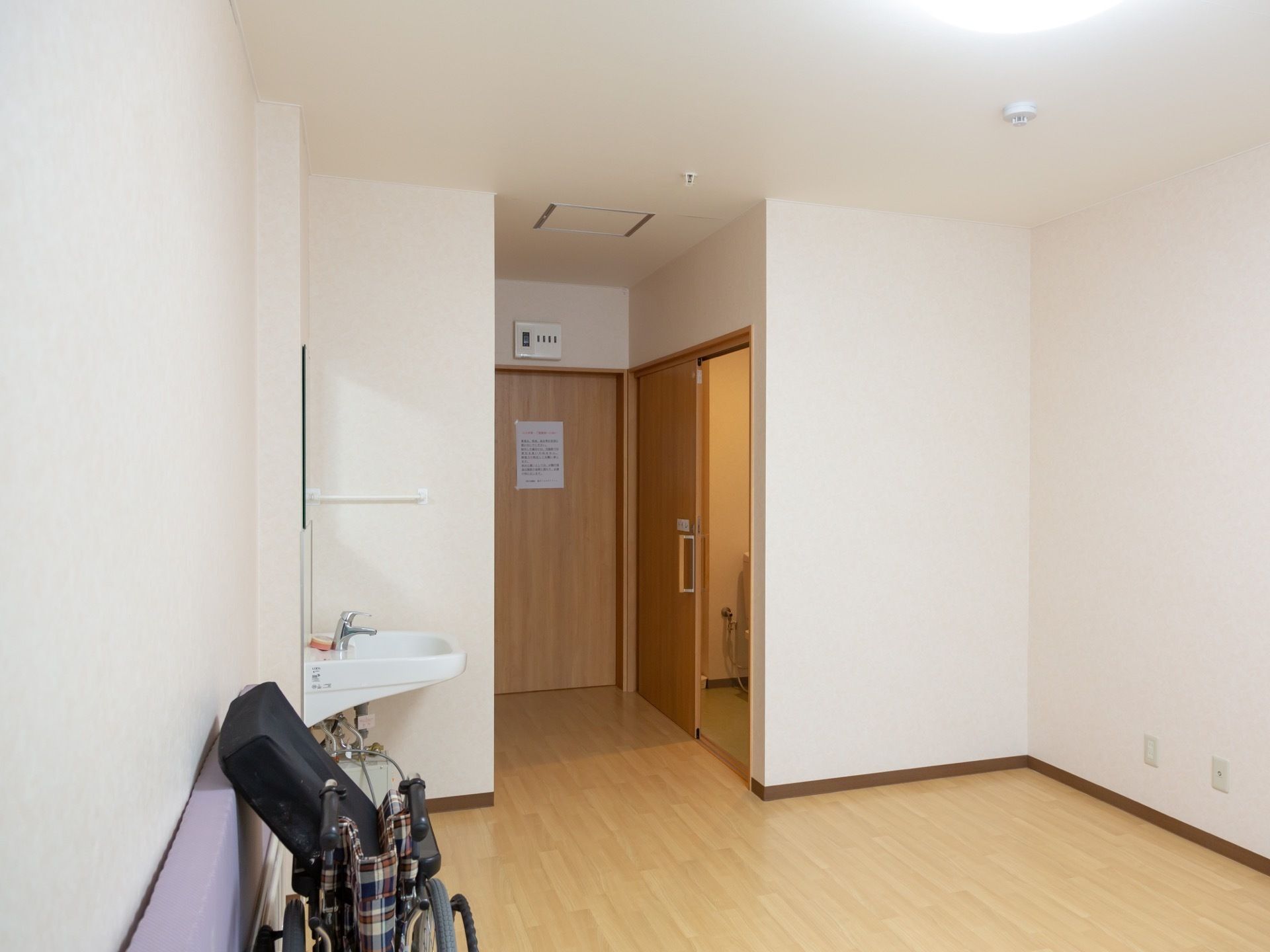 白い壁面で清潔感がある。居室入口とトイレ入口は幅が広く床がフラットなので、車椅子をご利用の方も快適である。