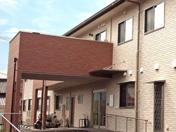 エントランスに続くスロープは傾斜が緩い。段差には手すり。雨でも濡れないよう、大きな屋根が張り出している。