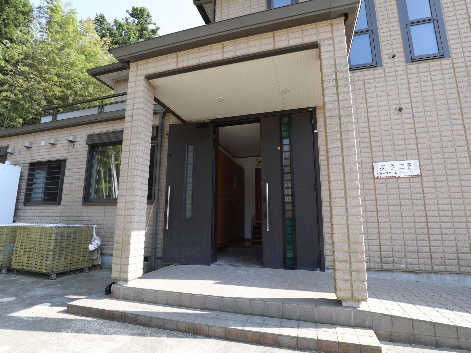施設の外観は、ベージュとダークブランでまとめられたシックな雰囲気である。玄関にはポーチがあり、スロープを備えている。
