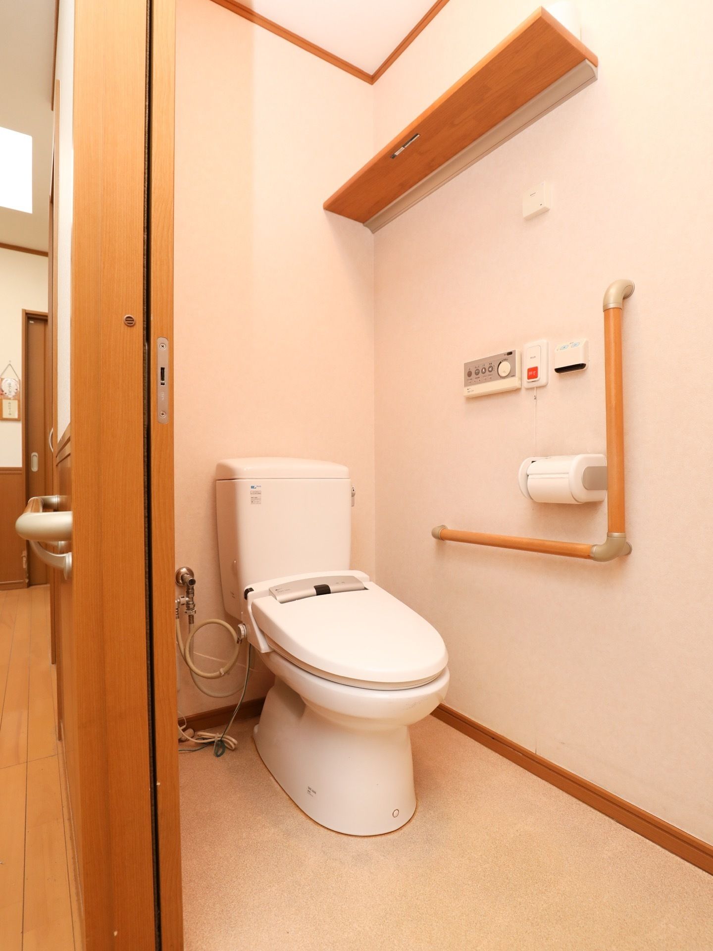 洋式トイレの個室内には、緊急をスタッフに知らせることができるボタンが取り付けられている。便座の周囲にはスペースが取られている。
