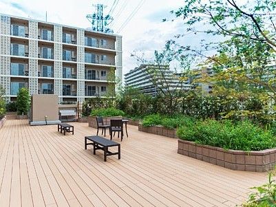 ５階建ての施設の前に広々としたスペースがある。各所に設けられた植え込みにはさまざまな植物を植えている。