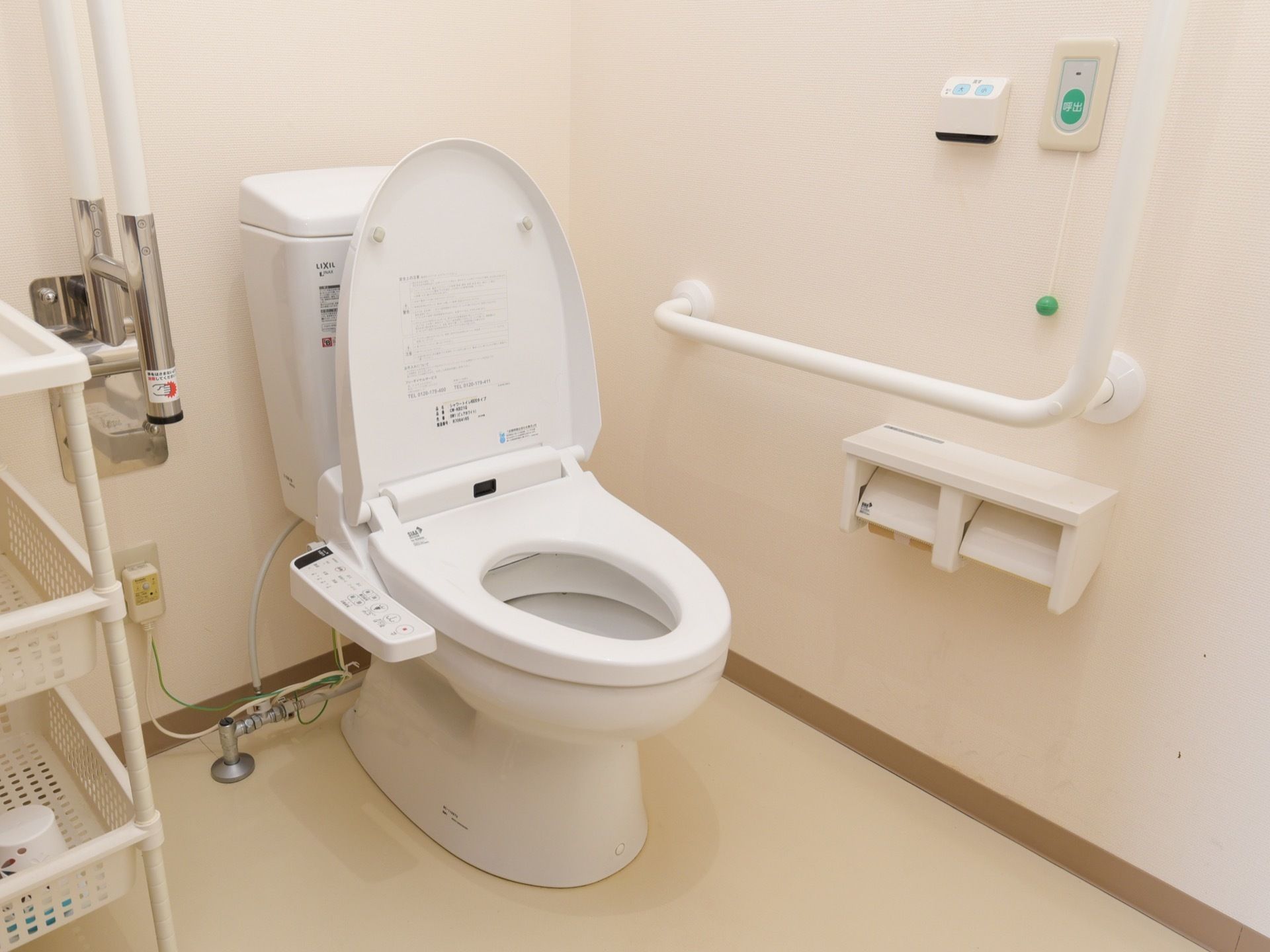 暖房便座付き温水洗浄トイレがある。壁には手すりと呼び出しボタンが設置されている。トイレットペーパーホルダーが2つある。