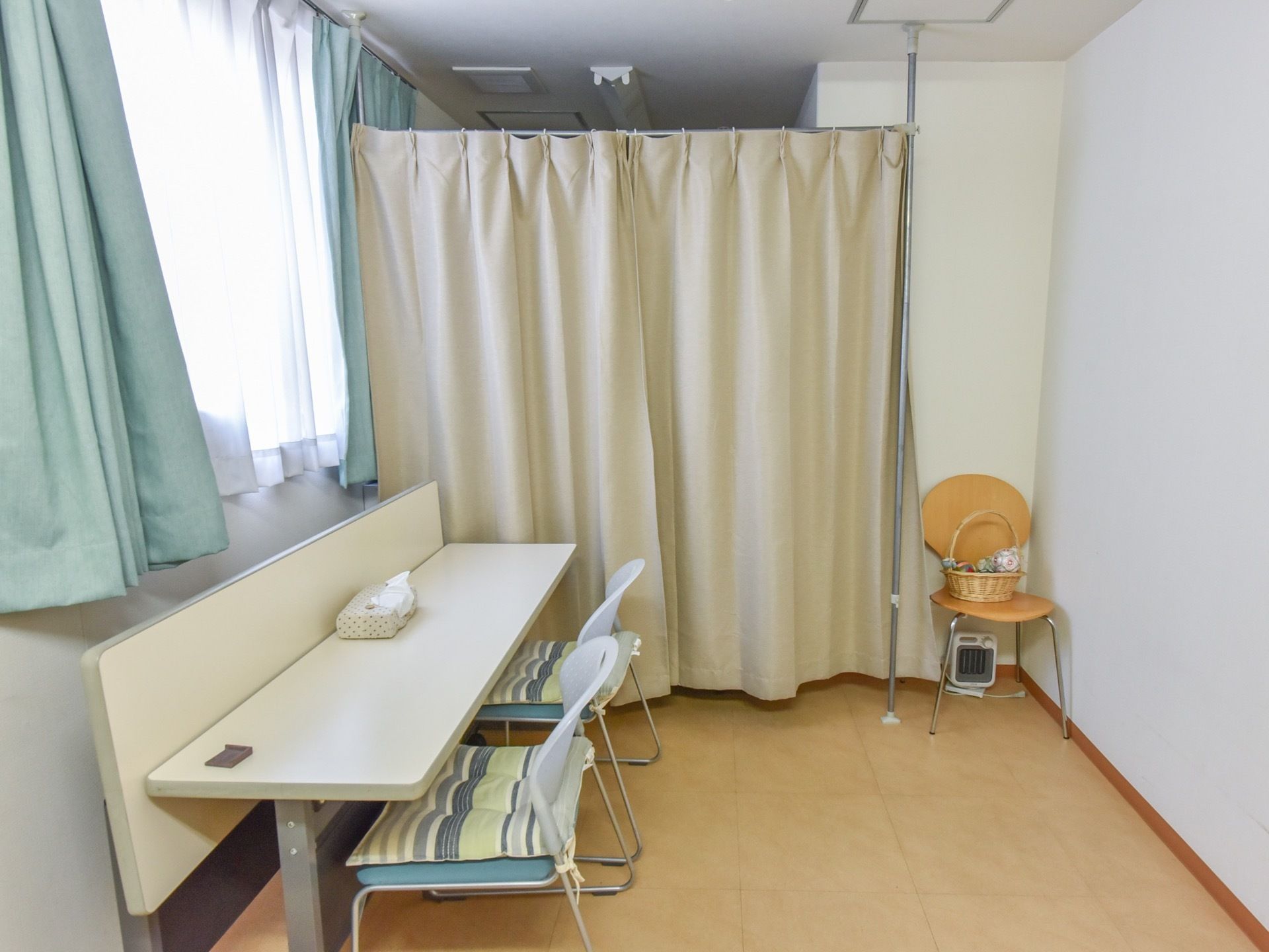 簡単なヒアリングなどをするスペースがあり、事務用机と椅子が用意されている。仕切りカーテンで区切られた着替え等をするスペースがある。