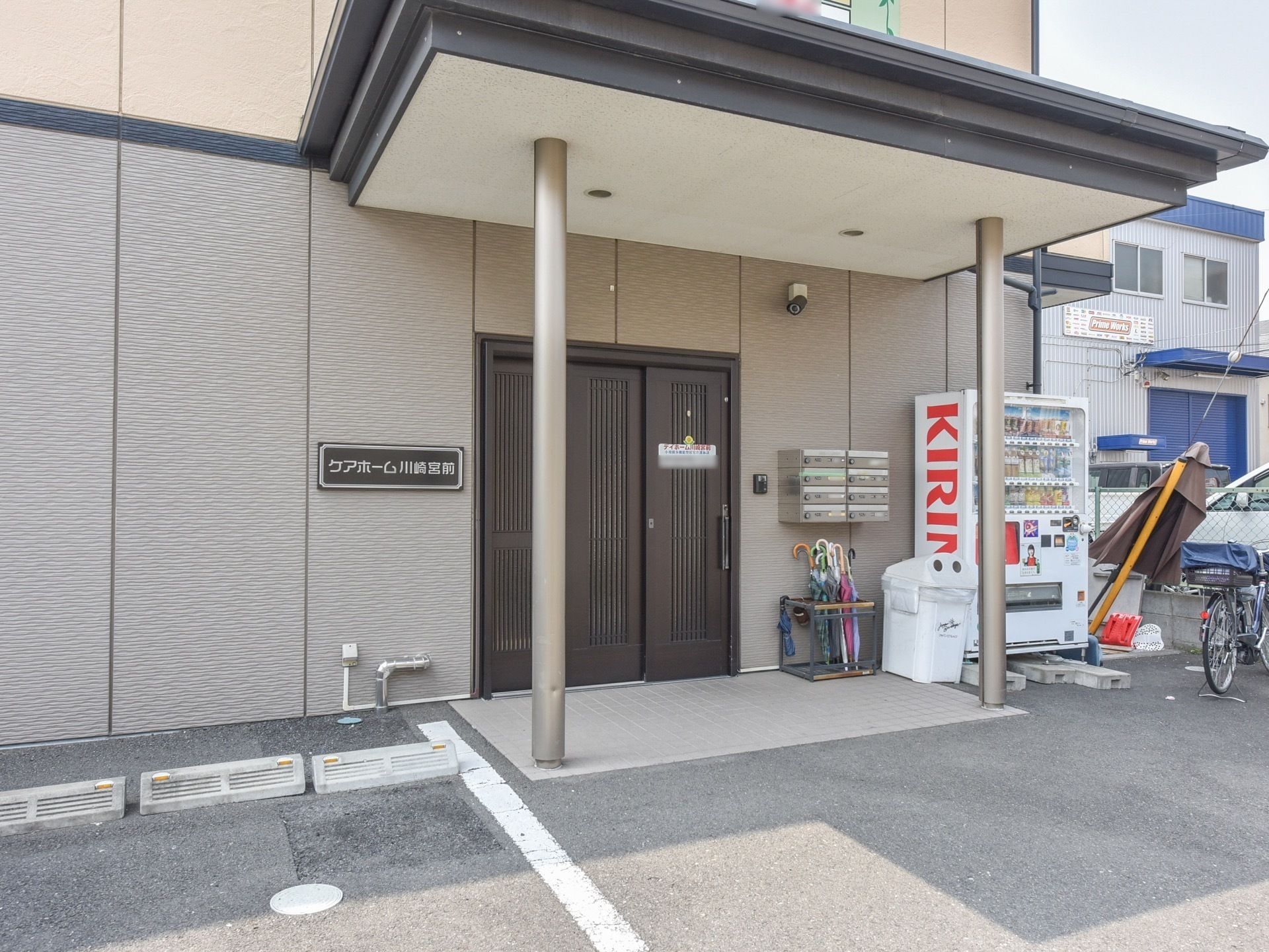 駐車場や自動販売機がすぐそばにある、段差のない施設の玄関