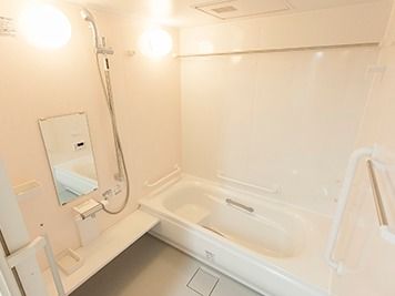 明るい浴室である。壁には鏡とシャワーが、天井には乾燥機が付いている。また、浴槽内浴槽周辺の壁には安全のため手すりが設置されている。