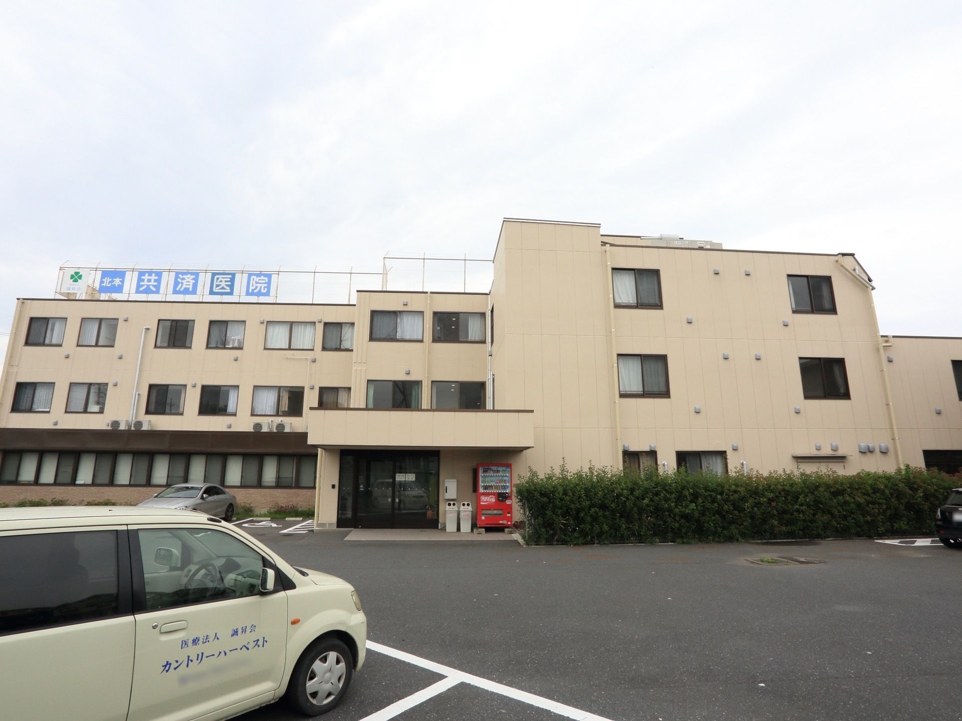 施設の建物全体を正面から写したものである。 出入り口の右横には、飲料の自動販売機とゴミ箱が設置されている。
