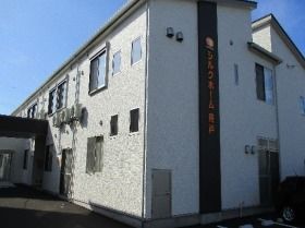 白い外壁で、バリアフリーに対応した2階建て施設の外観