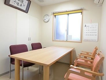 室内には木製のテーブル、手すり付きの椅子が置かれている。壁には窓が設置され、額装された書が飾られている。