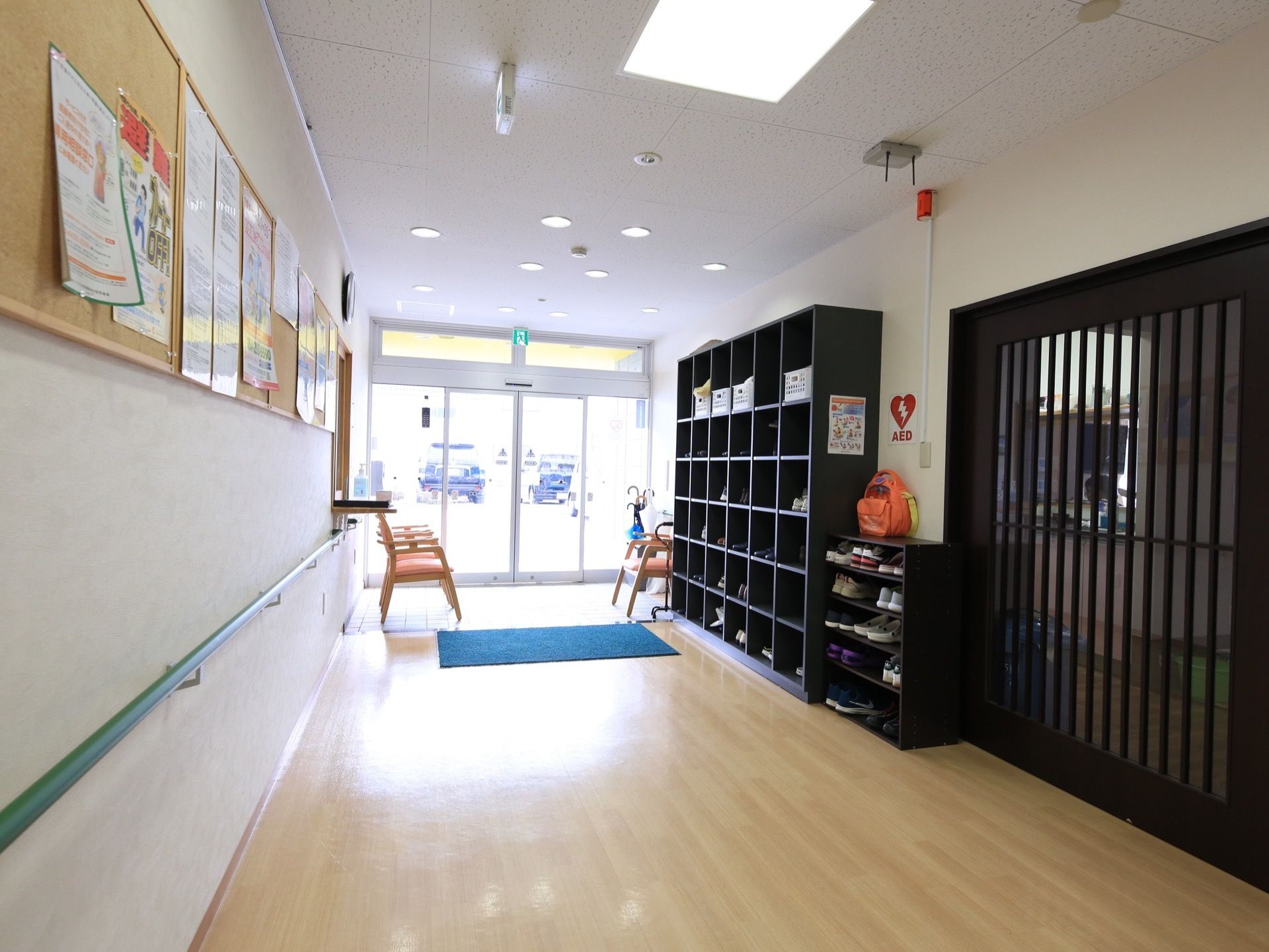 玄関から入る陽射しで明るい共用廊下。左側の壁には掲示板を設置している。施設の連絡事項などをいつでも確認することができる。