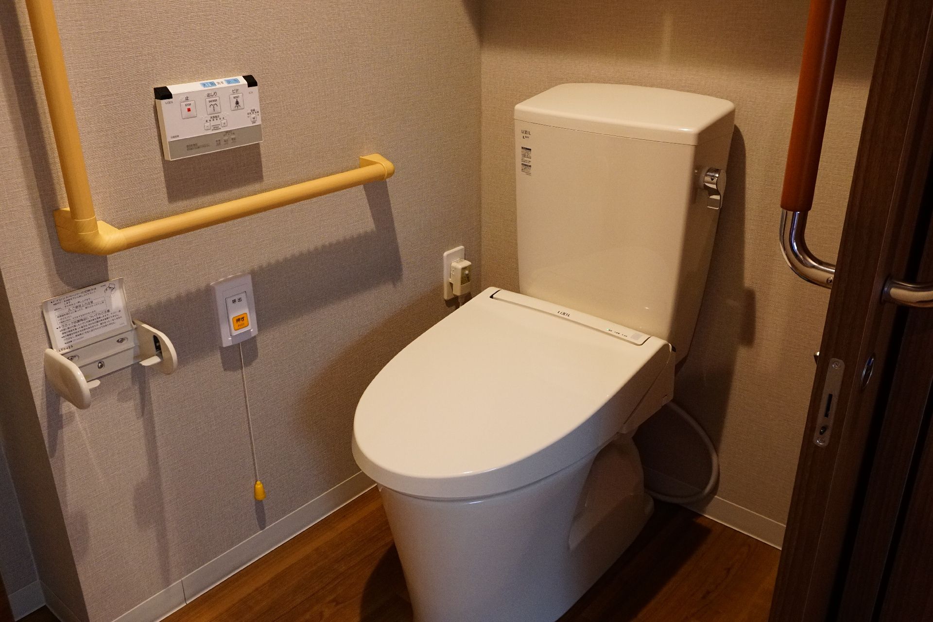 手すりが設置され、床に段差がほとんどない居室にあるトイレ