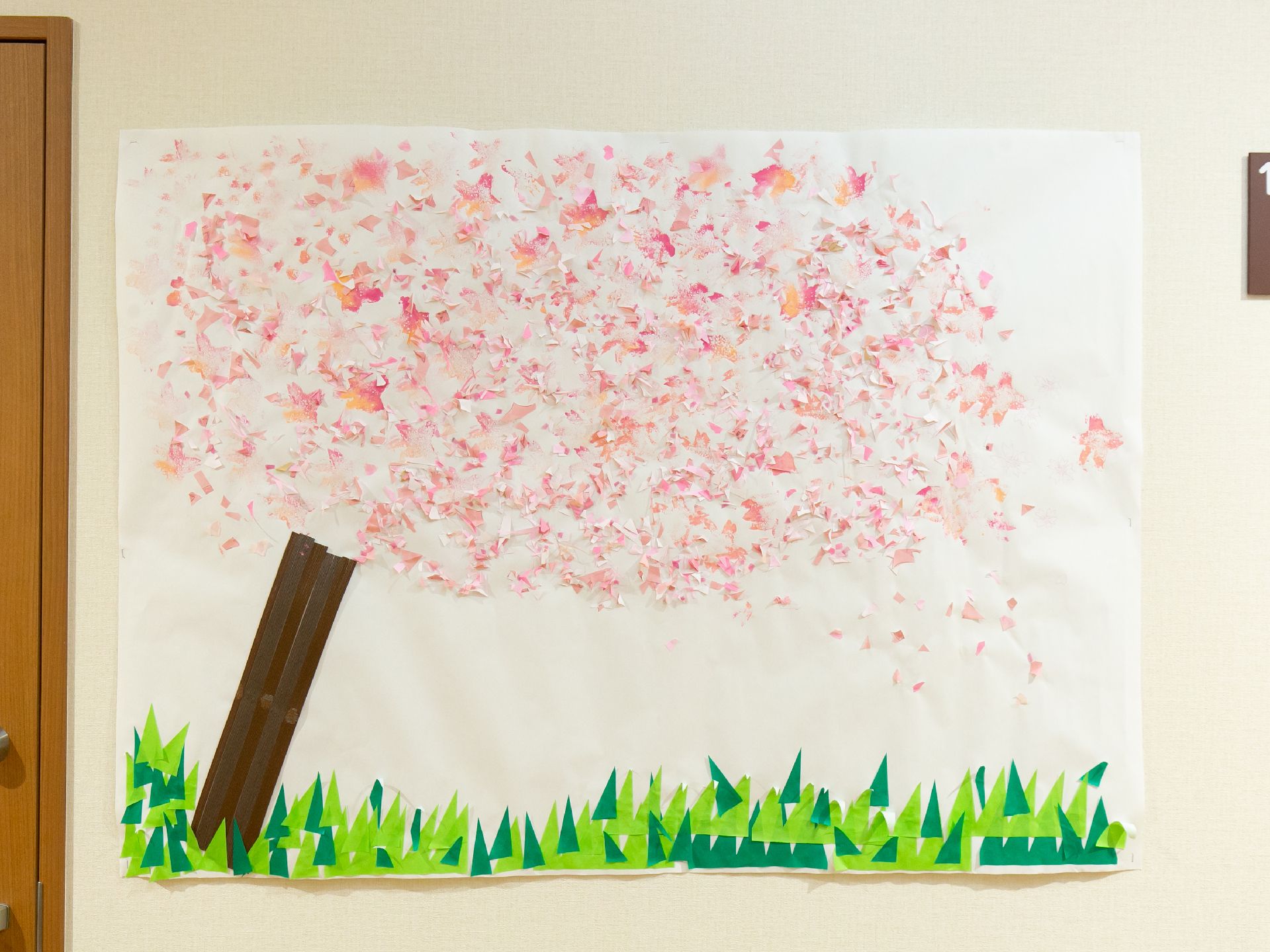 施設内の壁に飾られた、色合いのきれいな桜の木の貼り絵