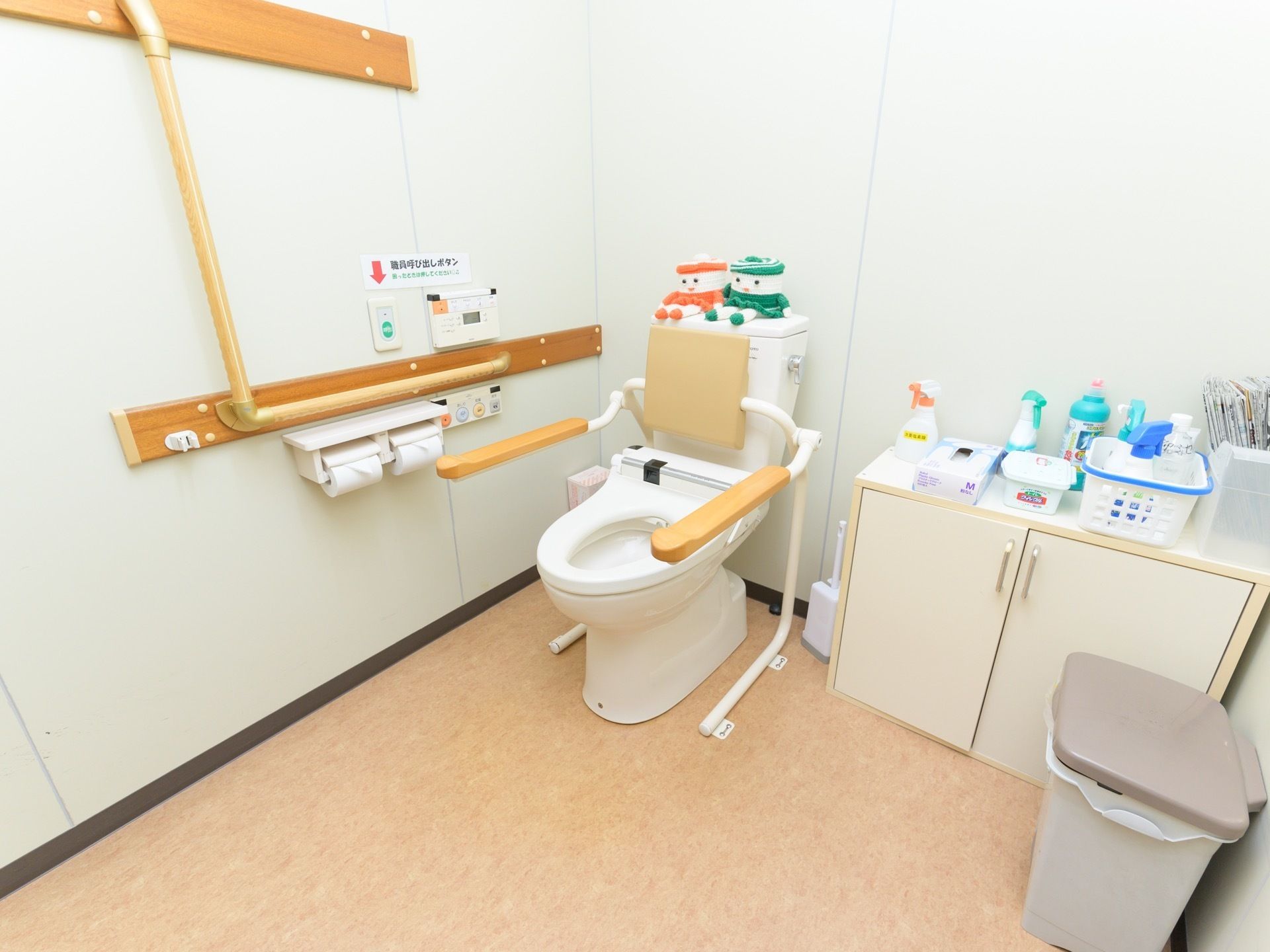 トイレは広いスペースに設置されている。便座横の棚の上には、掃除洗剤やふき取りシートなどが置かれている。