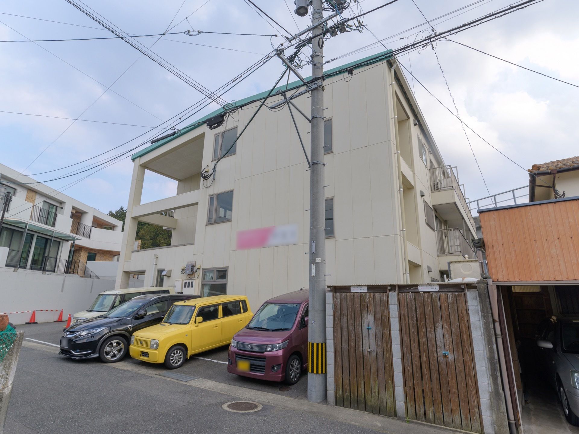 白色を基調とした外壁の３階建ての施設である。２階部分の壁に、提供サービスと施設名称が書かれた看板が設置されている。