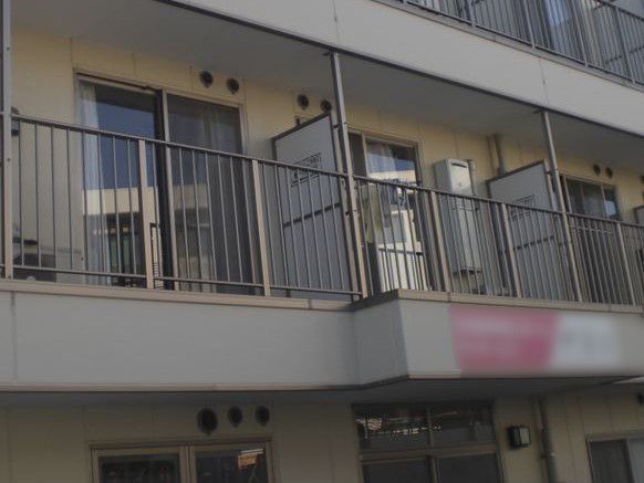 １階と２階の間の壁面に施設の看板を掲げている。ピンクと白のツートンカラーの背景に施設の種類と施設名を表示している。