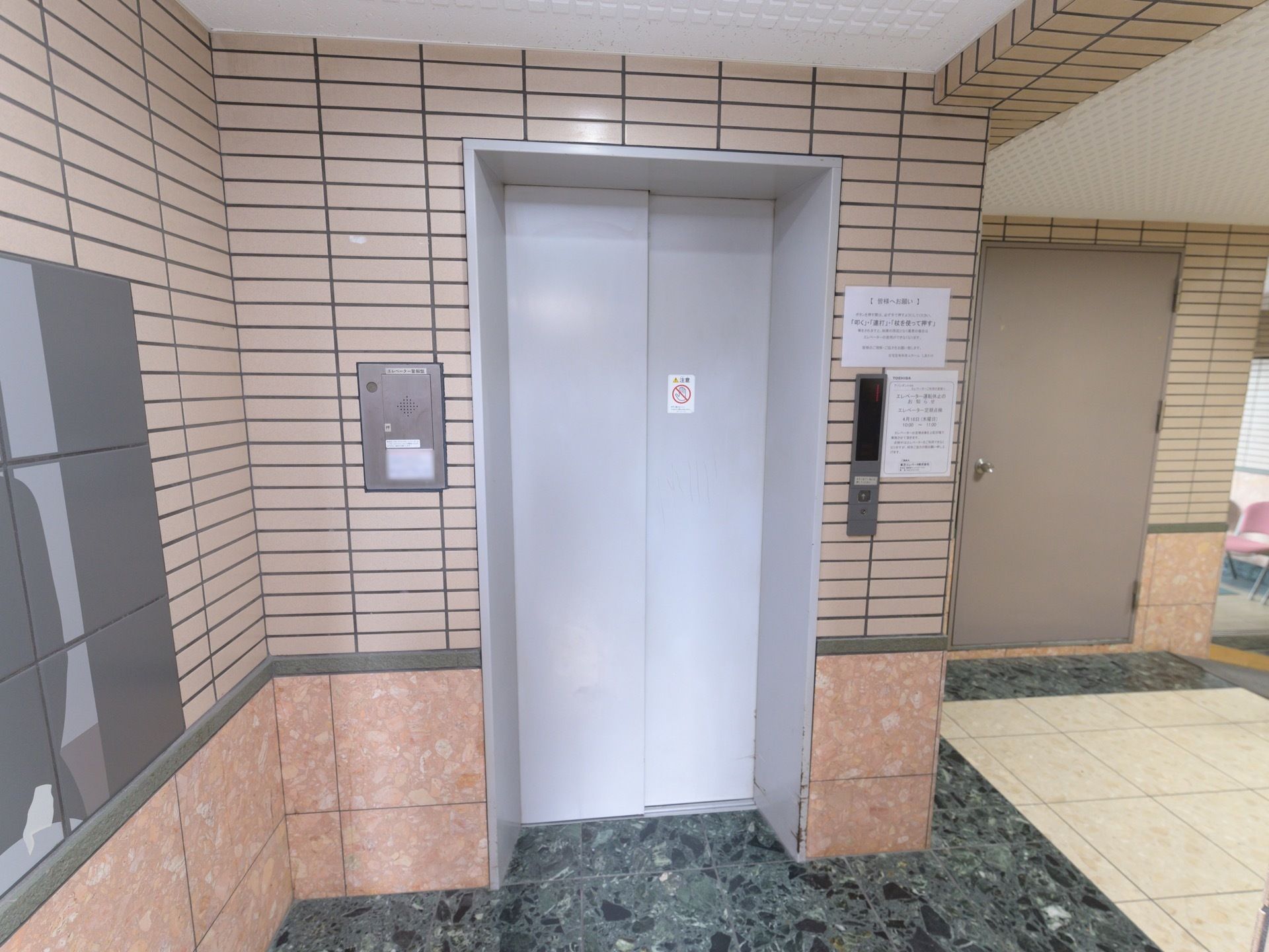 エレベーターが設置されている。スタッフに介助をお願いするときに使うインターホンが乗降口のすぐ横にある。