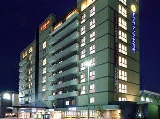 周囲の道路や建物の看板がライトアップされている施設建物