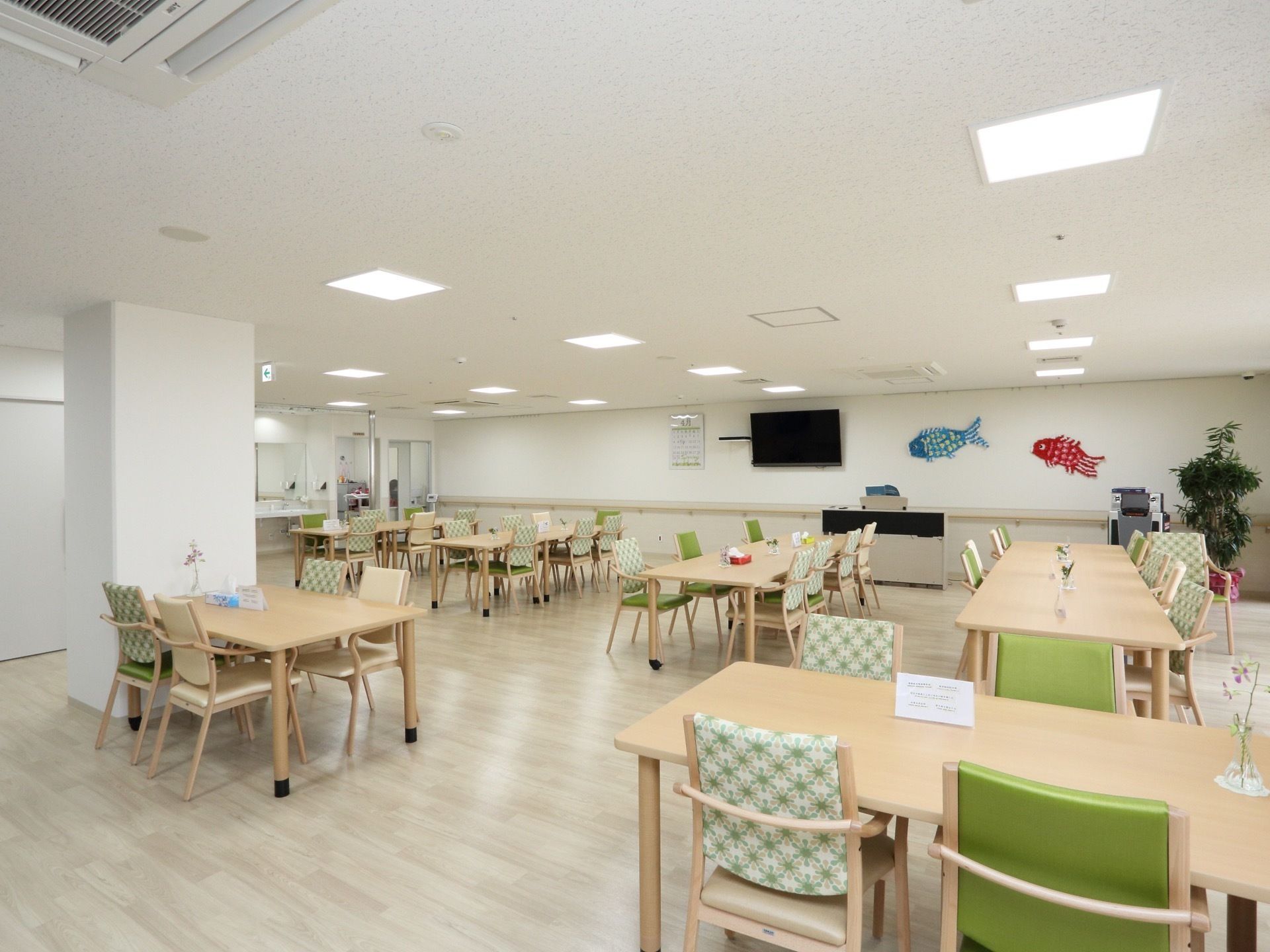 多数の椅子やテーブルが置かれている。壁にテレビが設置されていて、鯉のぼりが飾られている。広々とした空間である。