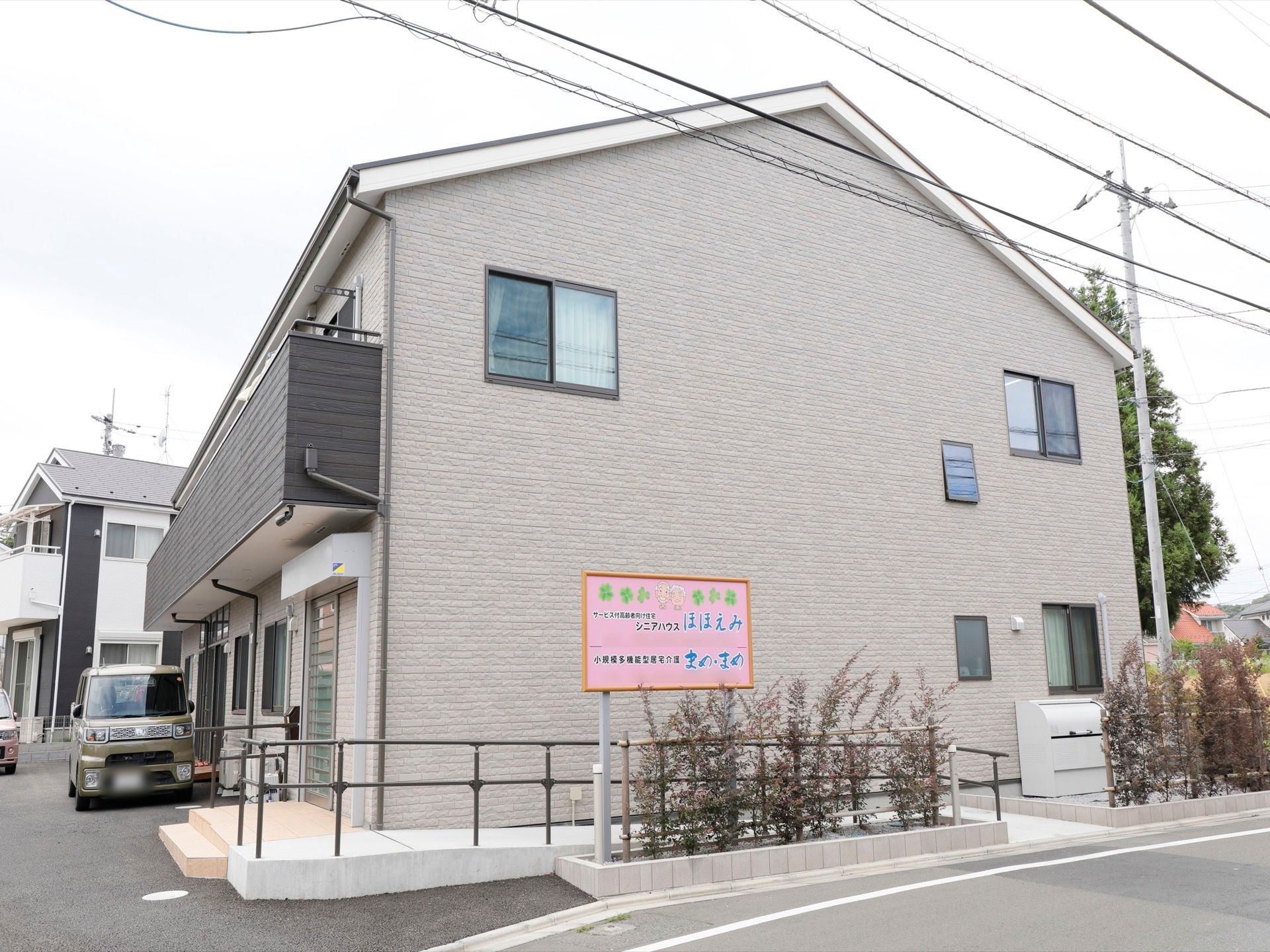 まわりの景観になじむ、落ち着いた色合いの外観である。スロープが設置されており、車椅子をご利用の方も安心して出入りできる。
