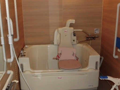 介護用の特殊浴槽は、淵の高さを上下に調節できるように設計されている。浴槽内の座椅子により、入居者様は座った体勢のまま入浴することができる。