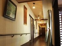 居室の扉がいくつか見えている。壁には絵画が掛けられている。手すりが設けられており、安全に通行することができる。
