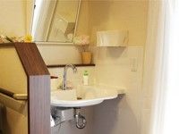 洗面台の鏡は傾斜がついているので、車椅子をご利用の方でも作業しやすい。洗面ボウルの下は広くスペースが設けられている。