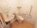 トイレには洋式便座の水洗トイレが置かれている。便座には可動式の手すりがある。手洗い洗面台も付いている。