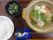 木のテーブルに並べられた、白ご飯と様々な食材を使用した料理