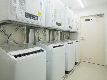 白い部屋に並んでいる、洗濯機とその上に取り付けられた乾燥機