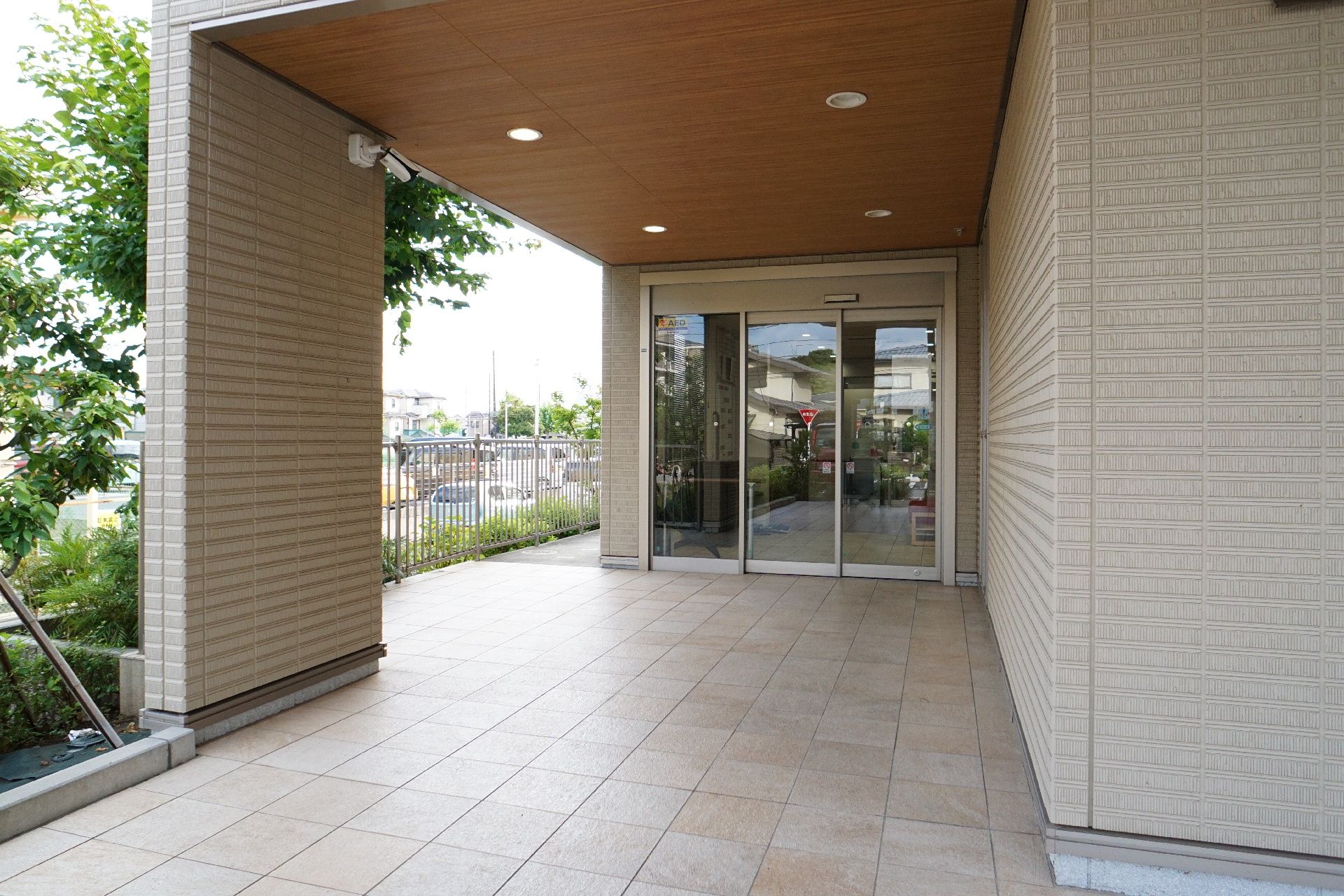 ベージュ色の建物の屋根がある入り口に設けられた自動ドア