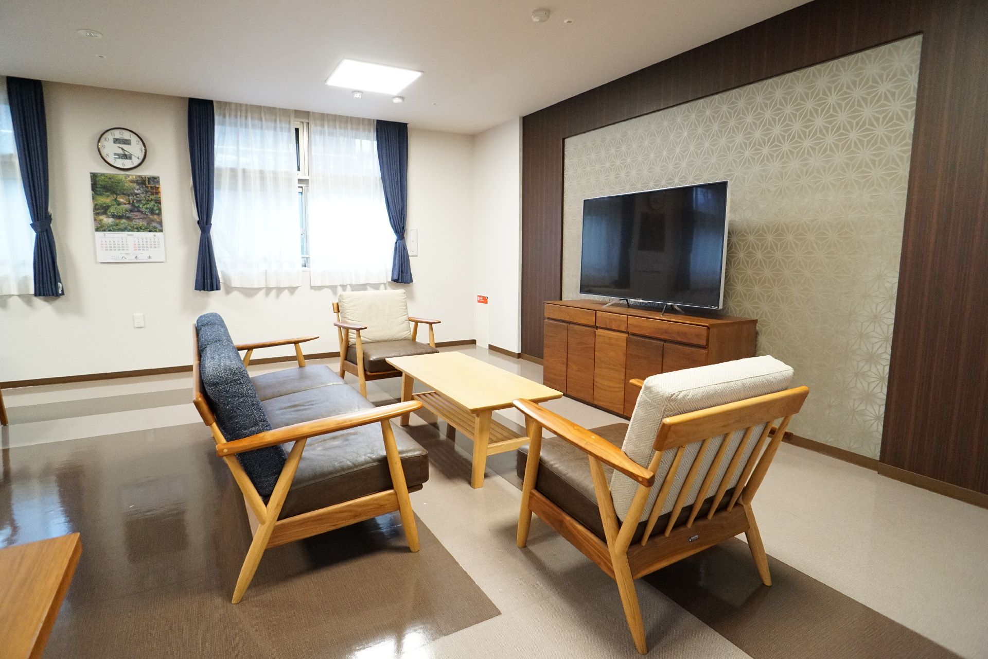 壁沿いに設置されたテレビを囲むように置かれた厚いクッションの椅子