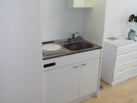 部屋の白いインテリアに合わせた、収納のついたミニキッチン