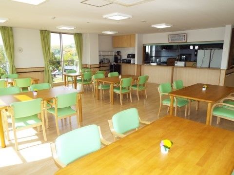 オープンキッチンが併設され、沢山のテーブルの並ぶ広い食堂