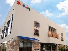 3階建てで、1階部分は車が入れるエントランスになった建物