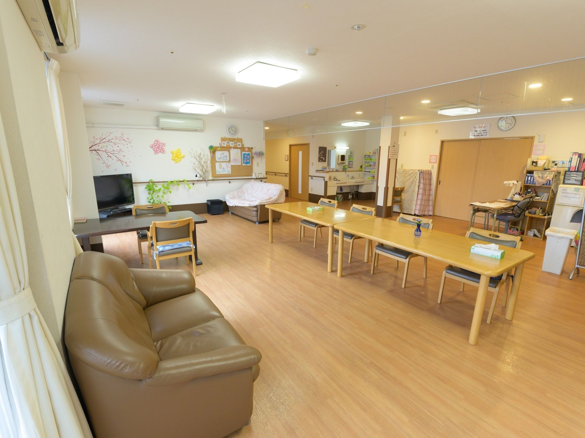 広々としたフローリングになっており、余計な家具が置かれていない。座り心地の良いソファが用意され、テレビも設置されている。