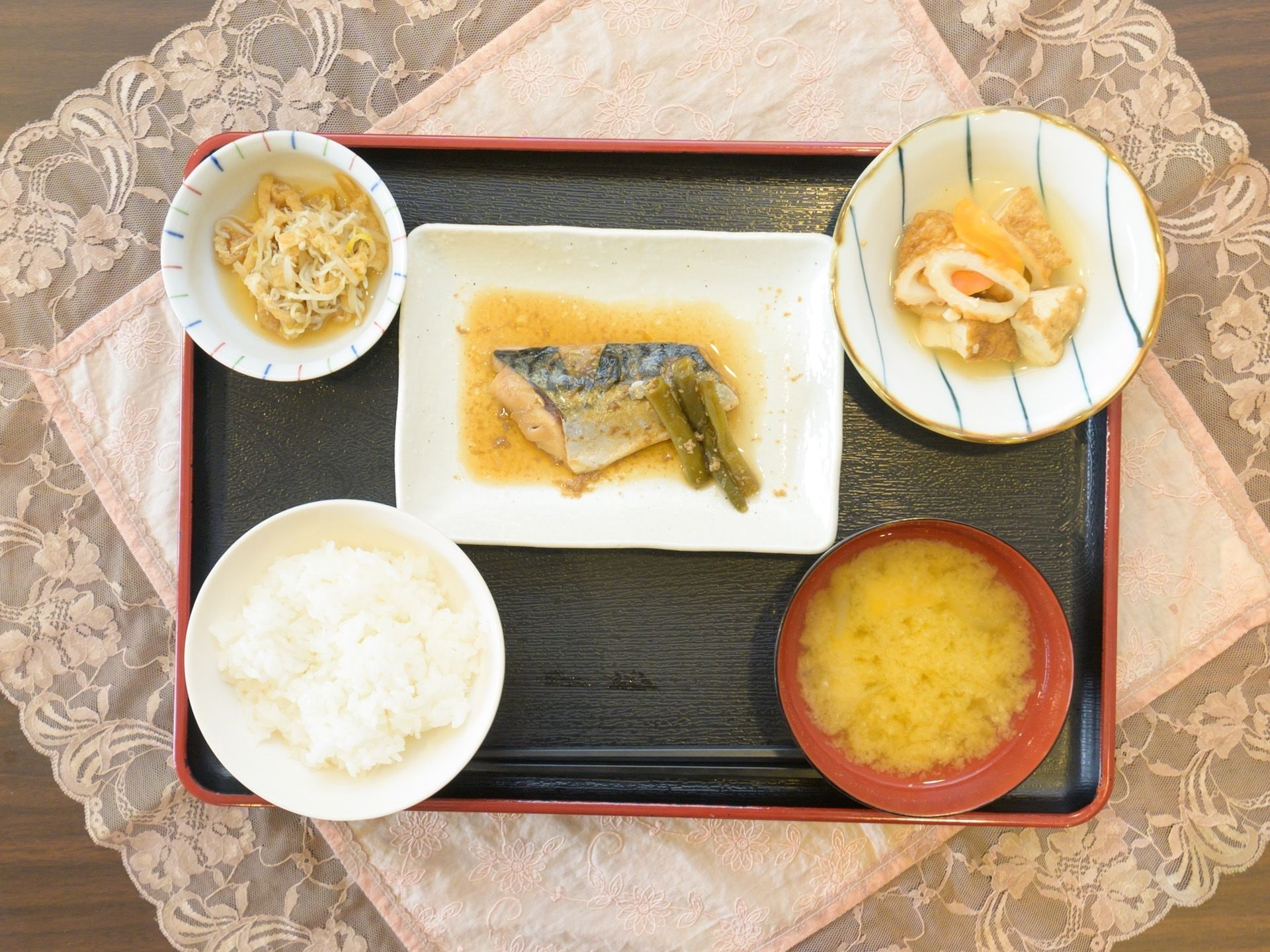 主菜、副菜、汁物と、バランスのとれた食事がお盆の上に用意されている。彩りも工夫されており、各おかずには野菜が添えられている。