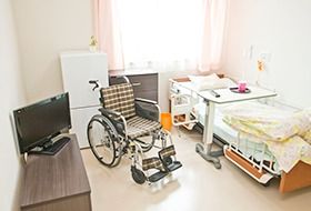 介護用ベッドや車椅子の置かれた高齢者施設の居室。