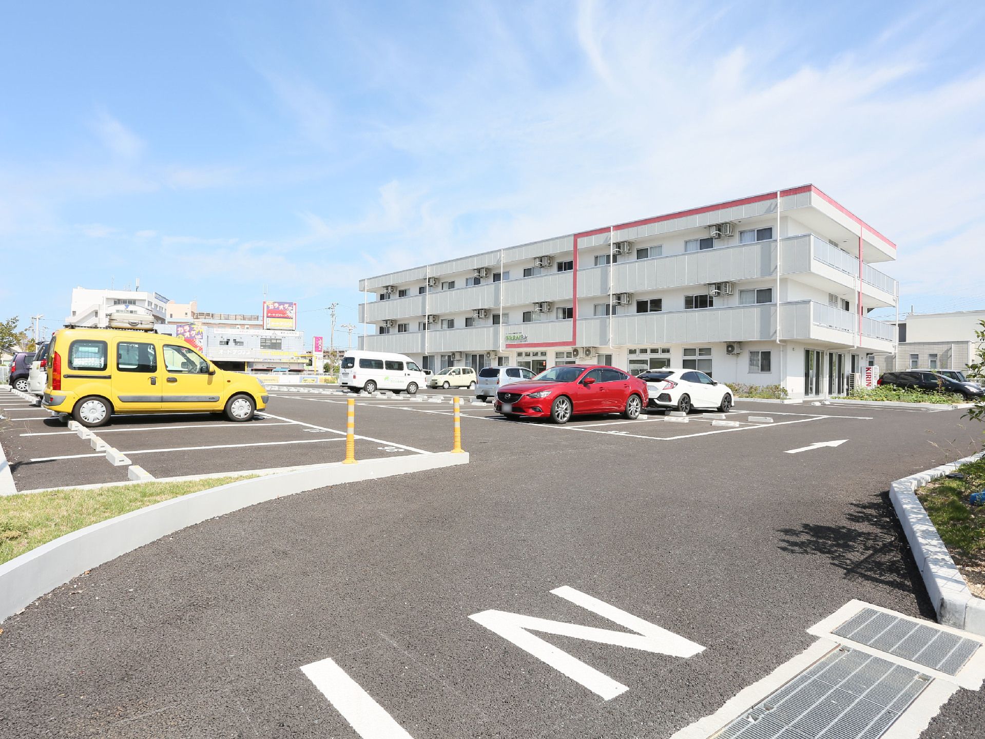 グレーに赤のラインが入った個性的な配色の高齢者施設外観。