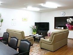 観葉植物が飾られた部屋のテレビの前に置かれたソファセット