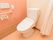 居室内にあるカーテンで仕切られたトイレである。温水洗浄便座が設置され、ケアコールや手すりも備え付けられている。