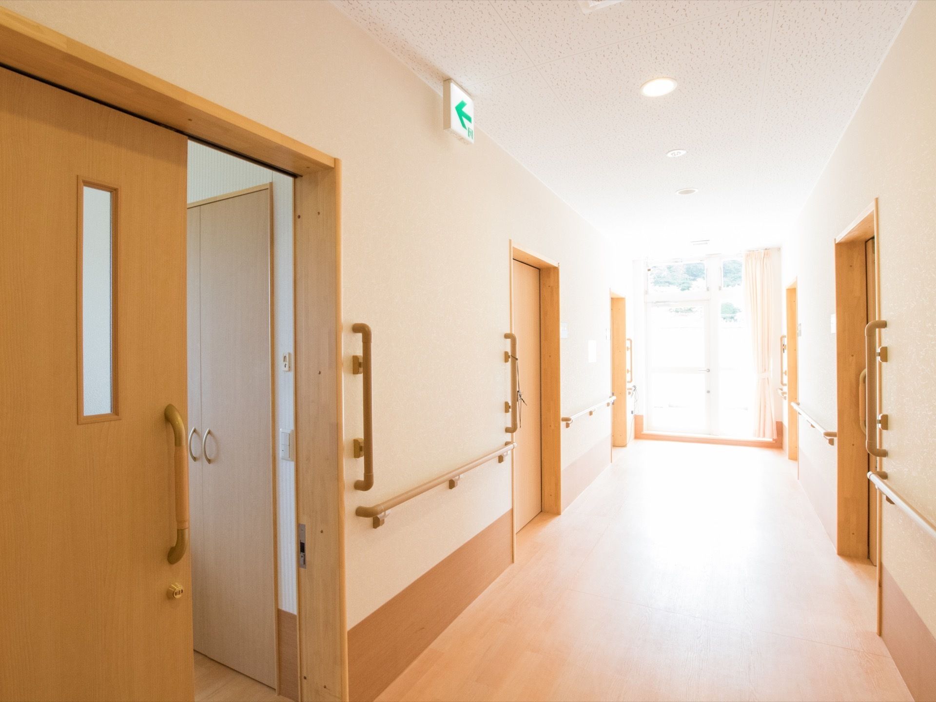 幅の広い廊下で左右両側に居室がある。廊下の端には窓が設置されており、日差しが差し込んで明るくなっている。