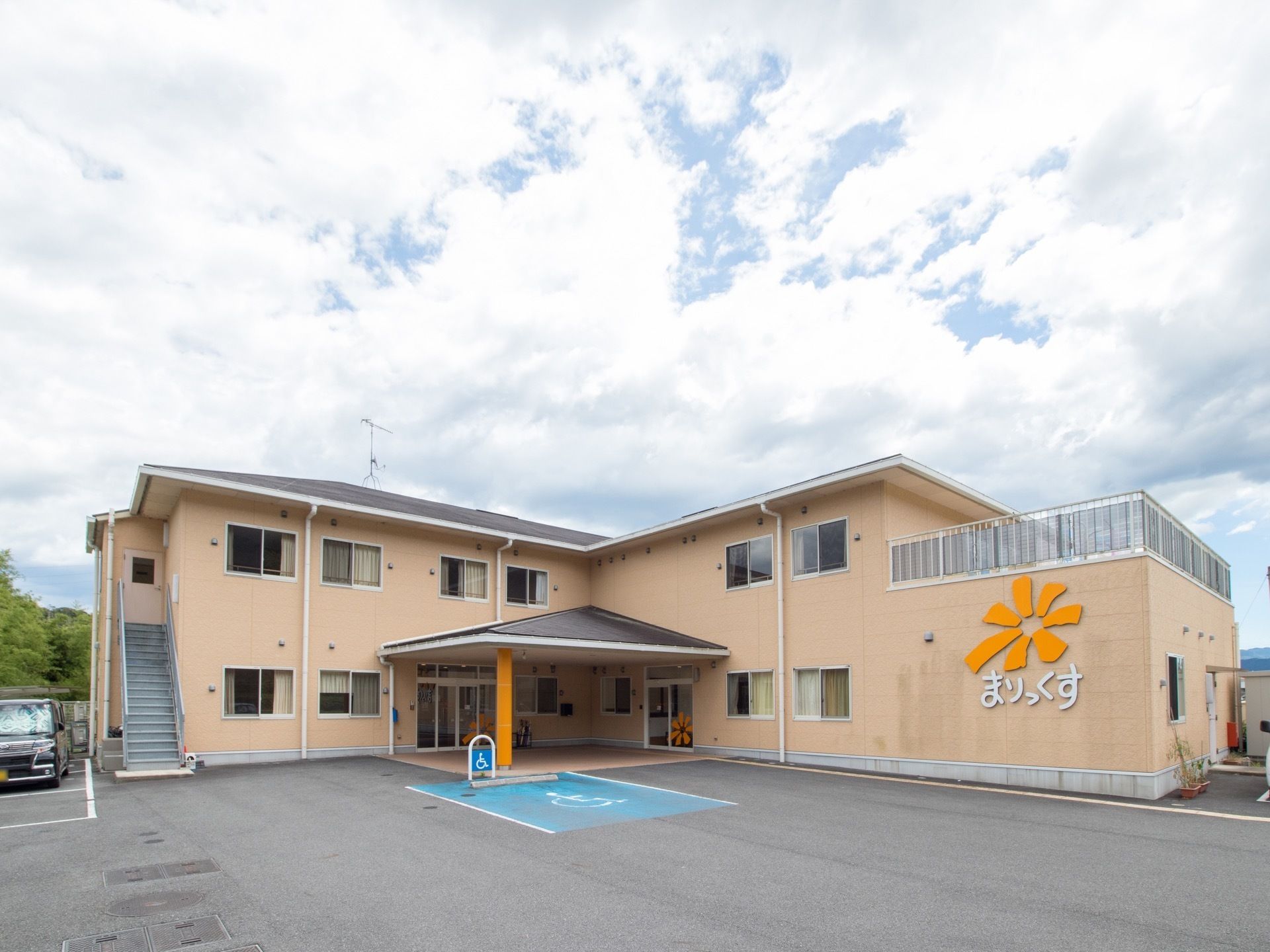 2階建の鉄筋コンクリート造の建物で、2階へと続く外階段が設置されている。施設前に車椅子マークが描かれた駐車スペースがある。