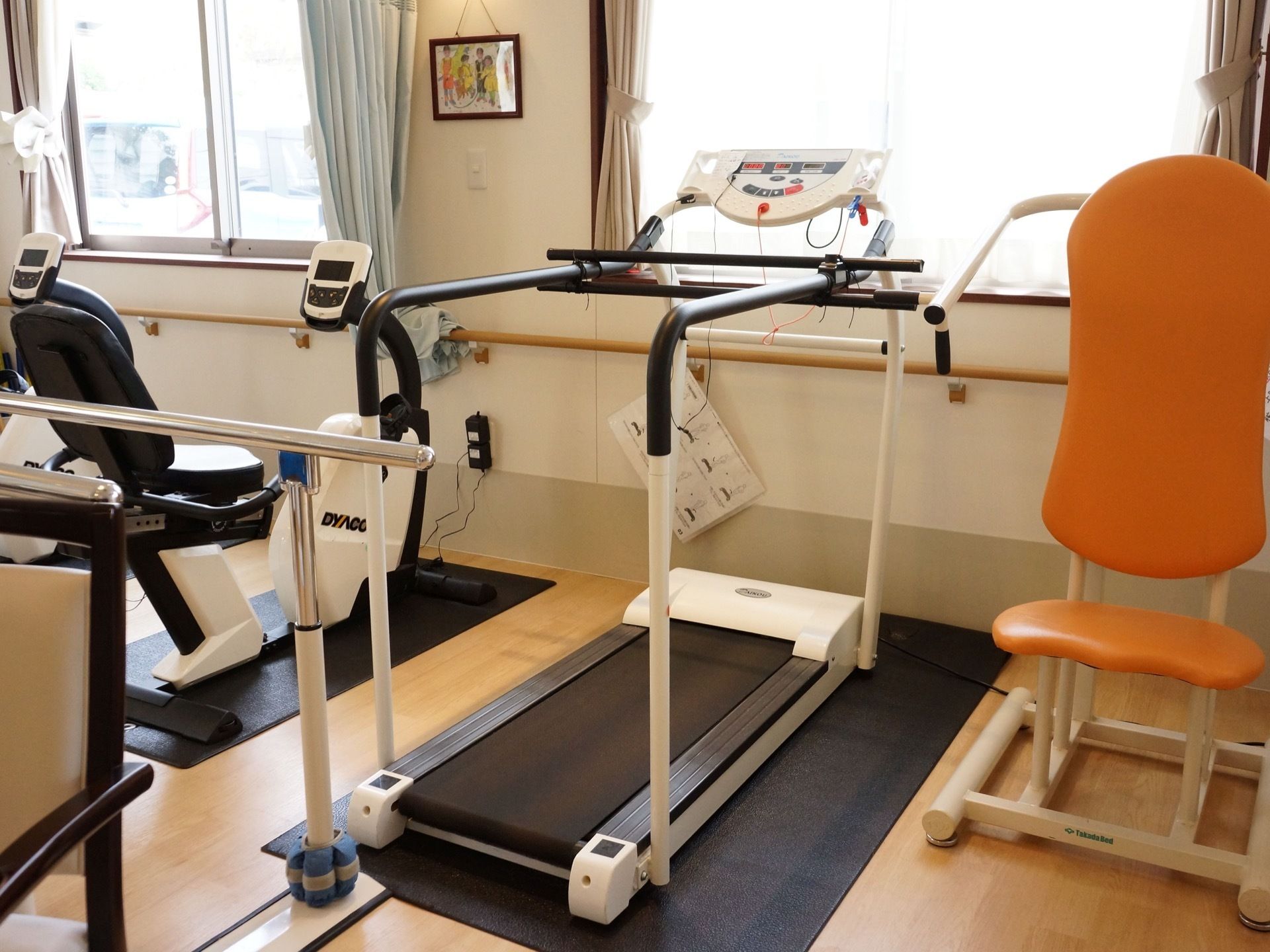入居者様の状況ごとに対応できるように、機能訓練室にはさまざまな種類の器具が揃えられている。入居者様だけでなく、デイサービス利用者もいる。