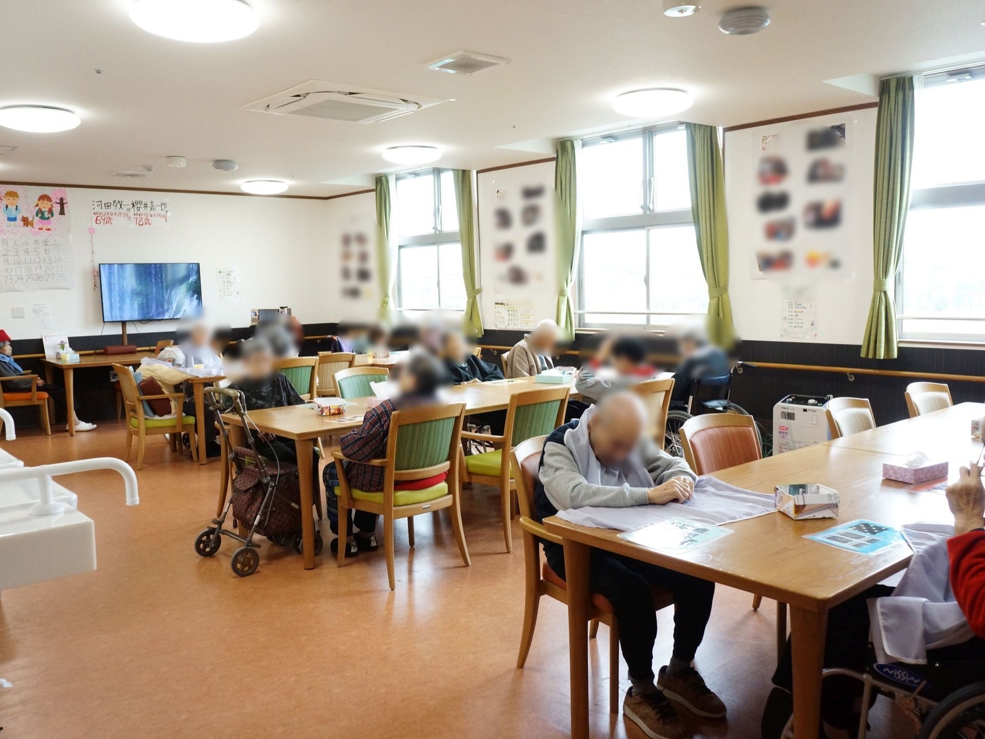 明るい食堂である。窓際の壁には行事の際に撮影された記念写真が掲示されており、入居者様はいつでも見ることができる。